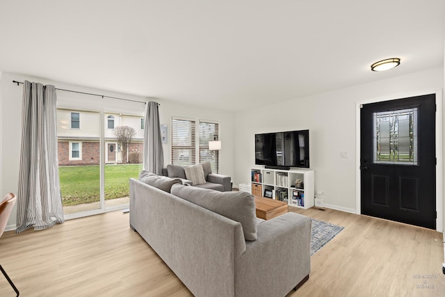 living area with baseboards and light wood finished floors