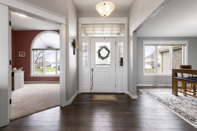 foyer with plenty of natural light, baseboards, visible vents, and hardwood / wood-style flooring