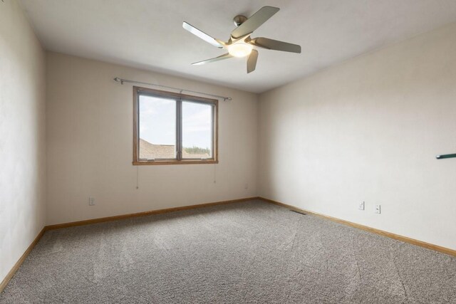 spare room with baseboards, a ceiling fan, and carpet flooring