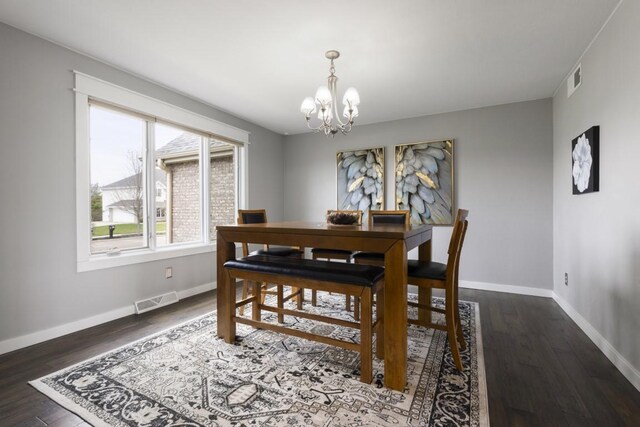dining space featuring baseboards, visible vents, a notable chandelier, and dark wood-style floors