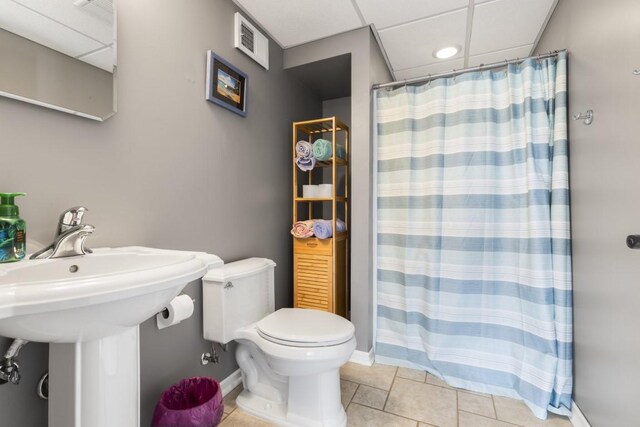 bathroom with tile patterned flooring, visible vents, toilet, baseboards, and a shower with shower curtain