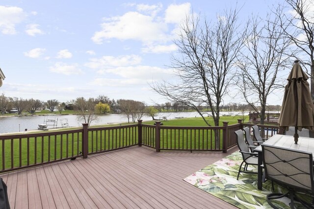 wooden deck featuring outdoor dining space, a lawn, and a water view