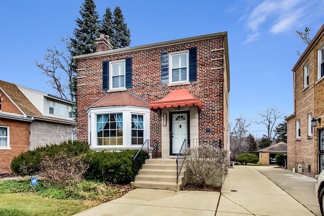 traditional home with a chimney and brick siding