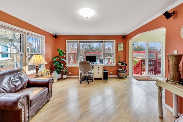 home office featuring arched walkways, crown molding, wood finished floors, and baseboards