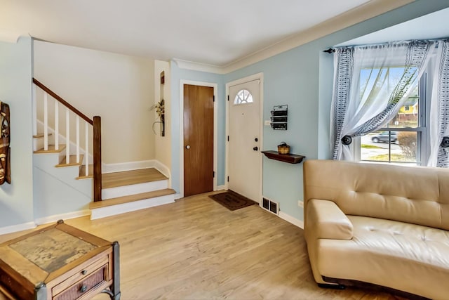 foyer entrance with wood finished floors, visible vents, baseboards, and stairway