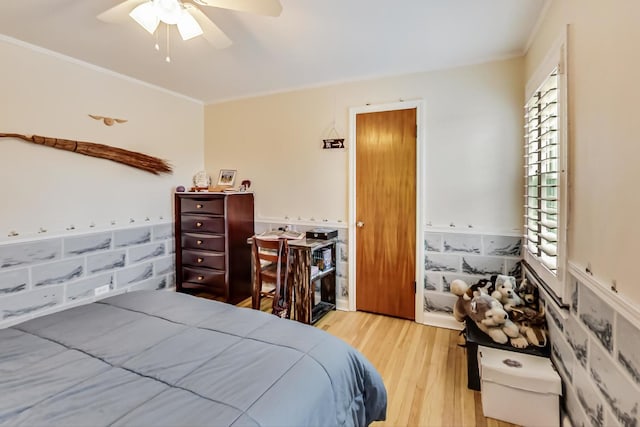 bedroom featuring ceiling fan, ornamental molding, and wood finished floors