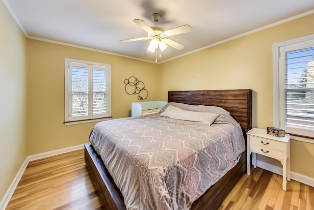 bedroom with baseboards, multiple windows, and wood finished floors