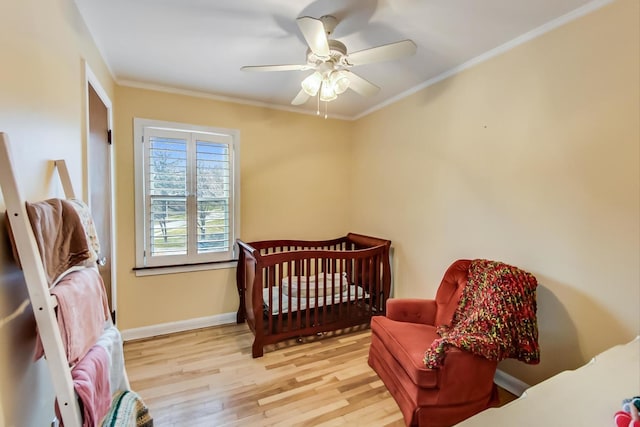 bedroom with baseboards, a ceiling fan, wood finished floors, and crown molding