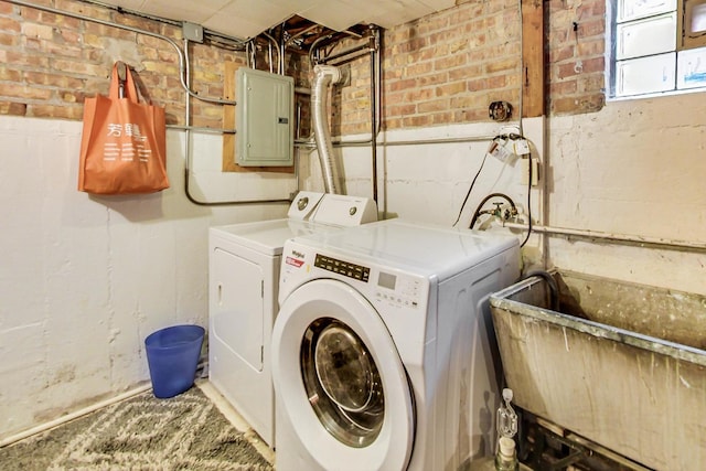 washroom featuring electric panel, laundry area, and washer and clothes dryer