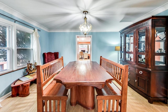 dining space with light wood-style flooring and crown molding