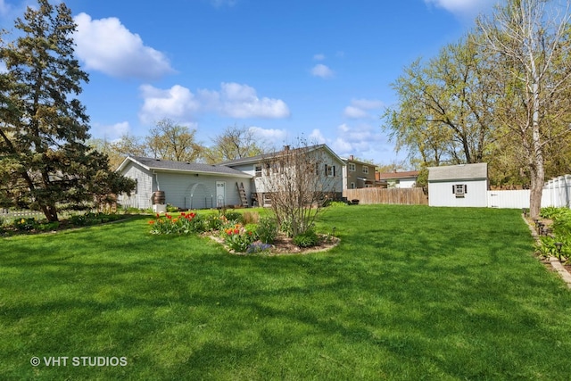 view of yard with an outdoor structure, a storage shed, and fence