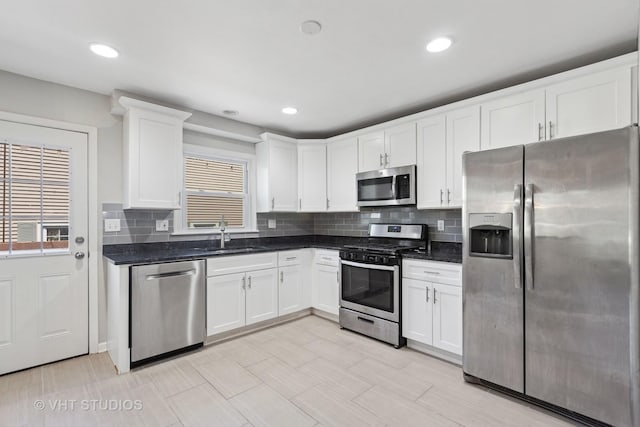 kitchen with white cabinetry, backsplash, appliances with stainless steel finishes, and a sink