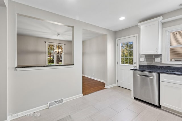 kitchen with an inviting chandelier, visible vents, baseboards, stainless steel dishwasher, and white cabinets
