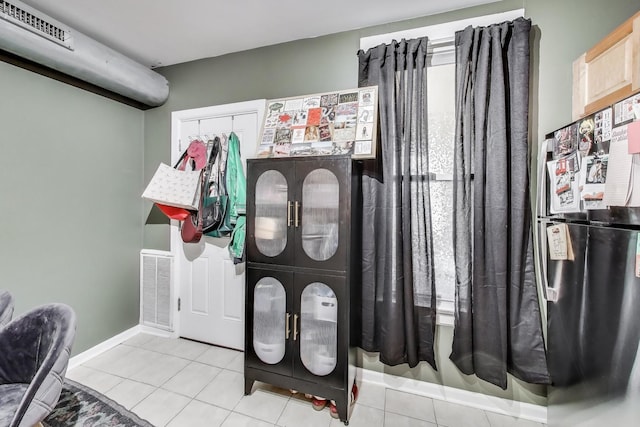 tiled foyer featuring baseboards and visible vents