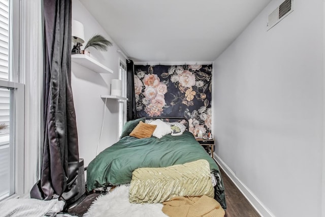 bedroom featuring visible vents, wood finished floors, and baseboards