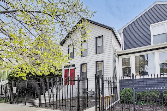 dutch colonial featuring a fenced front yard and a gate