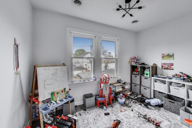 playroom featuring baseboards, visible vents, and wood finished floors