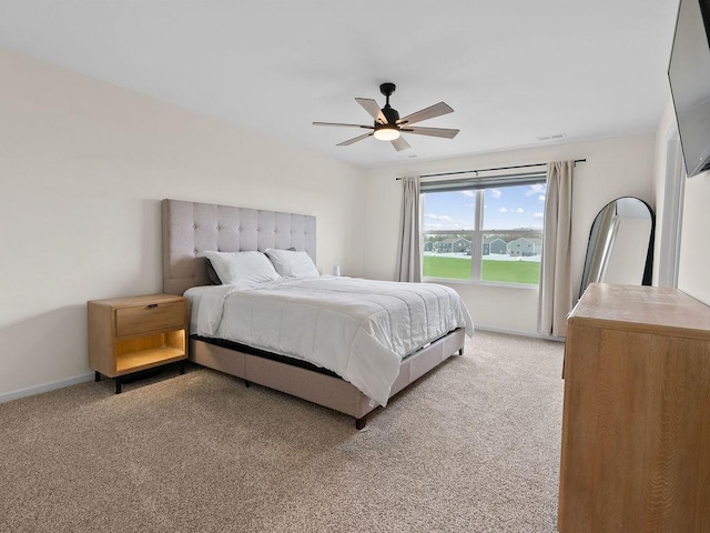 bedroom featuring light carpet, baseboards, and ceiling fan