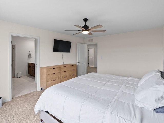 bedroom with ensuite bath, carpet flooring, a ceiling fan, and visible vents