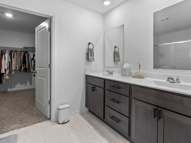 bathroom featuring double vanity, visible vents, marble finish floor, and a sink