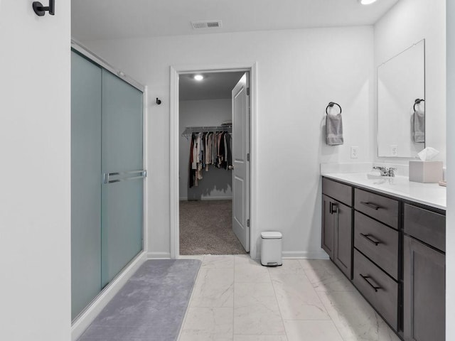 bathroom featuring a shower stall, a spacious closet, vanity, marble finish floor, and visible vents