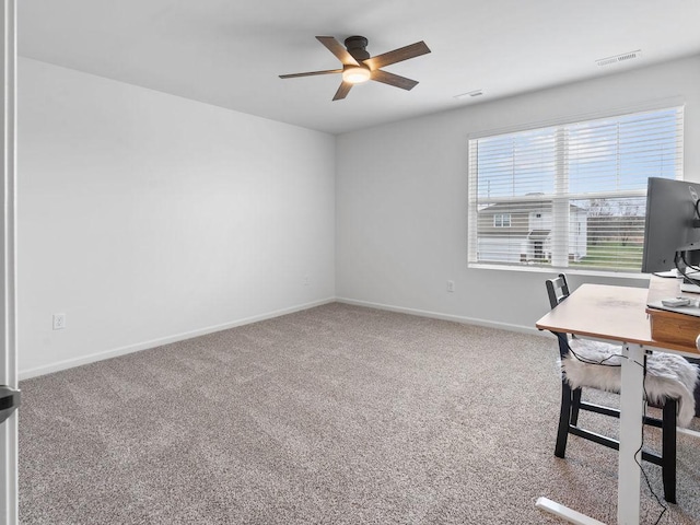 unfurnished office featuring baseboards, visible vents, carpet, and ceiling fan