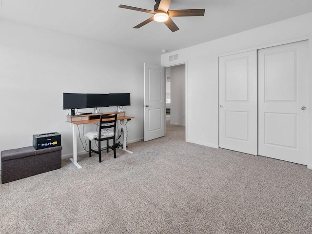 carpeted office featuring baseboards, a ceiling fan, and visible vents
