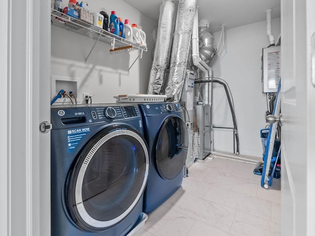washroom featuring washing machine and dryer, marble finish floor, and laundry area