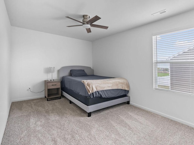 bedroom featuring baseboards, visible vents, carpet, and multiple windows