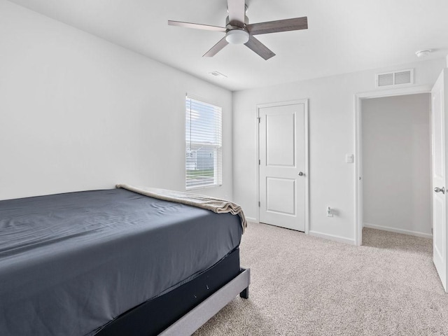 bedroom with light carpet, a ceiling fan, visible vents, and baseboards