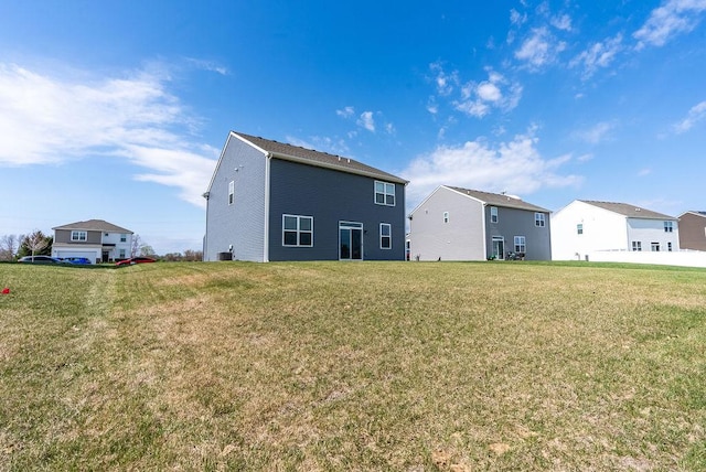 rear view of property featuring a yard and a residential view
