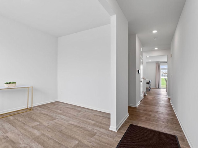 hall with baseboards, wood finished floors, and recessed lighting