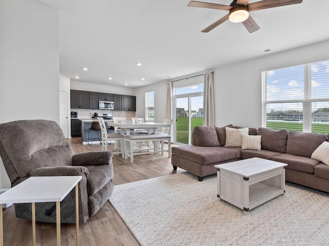 living area featuring recessed lighting, visible vents, light wood finished floors, and ceiling fan