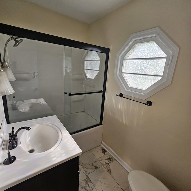 full bath with marble finish floors, toilet, vanity, combined bath / shower with glass door, and baseboards