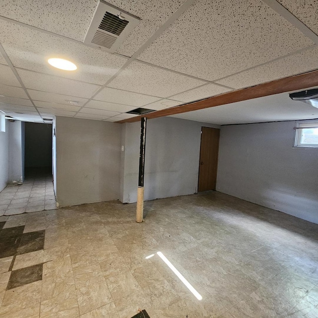below grade area featuring light floors and a paneled ceiling