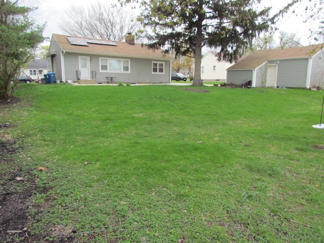 view of green lawn featuring an outdoor structure