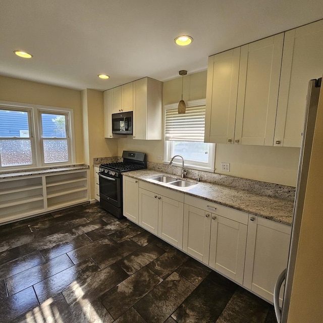 kitchen with appliances with stainless steel finishes, a sink, healthy amount of natural light, white cabinets, and recessed lighting