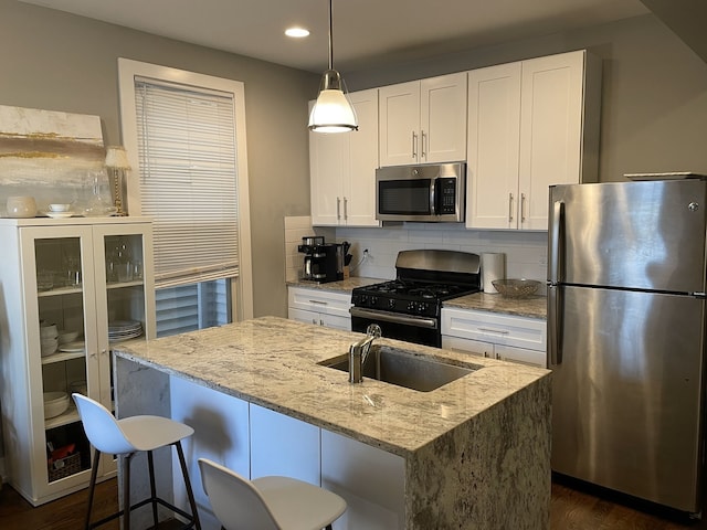 1941 W Roscoe St, Chicago, IL 60657 - kitchen featuring stainless steel appliances, a sink, recessed lighting, white cabinetry, and light stone counters