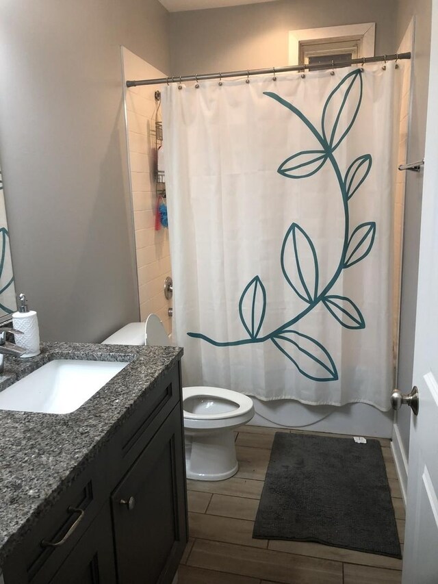 1941 W Roscoe St, Chicago, IL 60657 - full bathroom featuring wood finished floors, shower / bath combo with shower curtain, toilet, and vanity