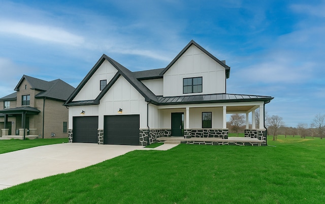 modern farmhouse with a standing seam roof, a front yard, board and batten siding, and covered porch