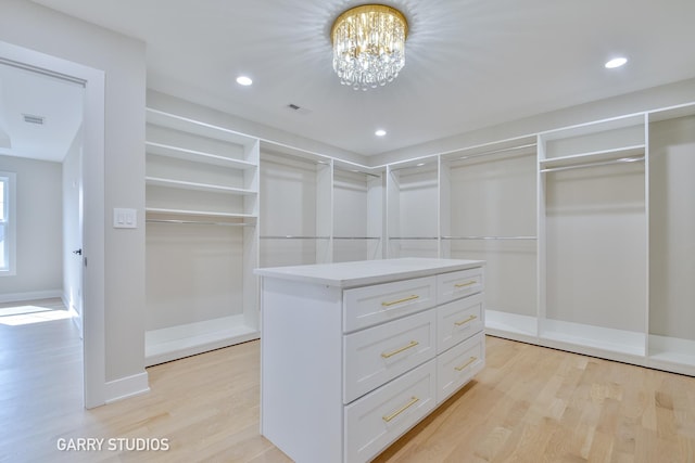 walk in closet with an inviting chandelier, visible vents, and light wood finished floors