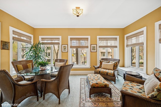 carpeted dining space featuring ornamental molding and plenty of natural light