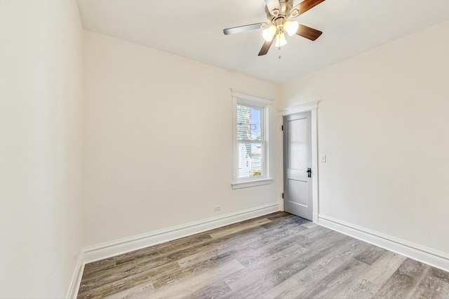 unfurnished room with ceiling fan, wood finished floors, and baseboards