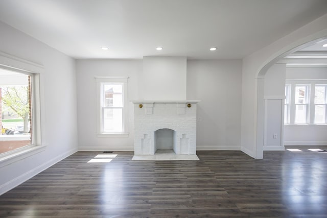 231 S Chicago Ave, Kankakee, IL 60901 - unfurnished living room featuring recessed lighting, arched walkways, baseboards, a fireplace, and dark wood-style flooring