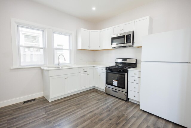 231 S Chicago Ave, Kankakee, IL 60901 - kitchen with stainless steel appliances, light countertops, wood finished floors, visible vents, and white cabinetry