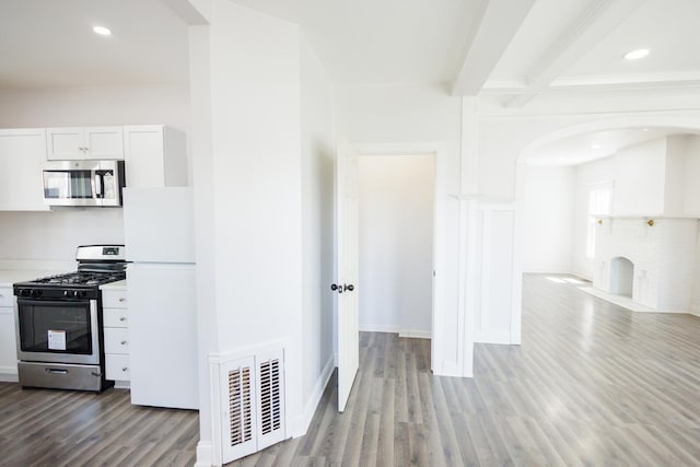 231 S Chicago Ave, Kankakee, IL 60901 - kitchen with beam ceiling, arched walkways, visible vents, wood finished floors, and appliances with stainless steel finishes