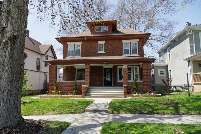 231 S Chicago Ave, Kankakee, IL 60901 - american foursquare style home featuring brick siding, a porch, and a front lawn