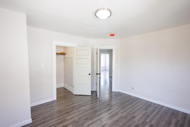 231 S Chicago Ave, Kankakee, IL 60901 - unfurnished bedroom featuring baseboards, dark wood-style flooring, and a closet