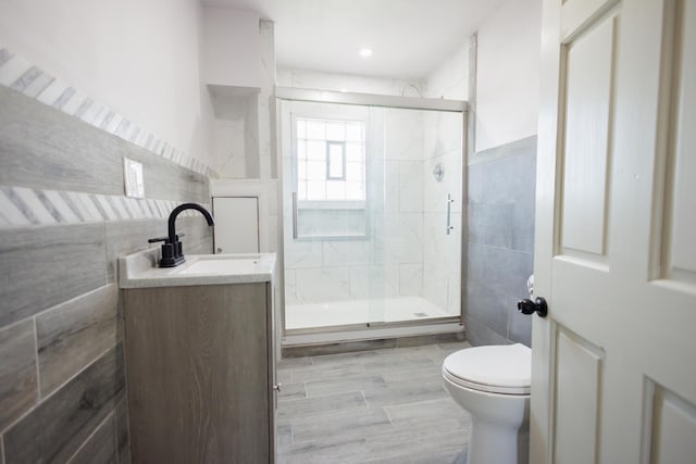 231 S Chicago Ave, Kankakee, IL 60901 - full bath featuring tile walls, vanity, toilet, and a stall shower