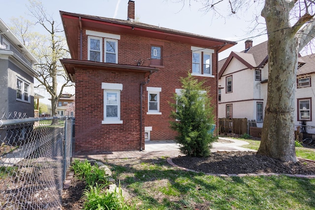 231 S Chicago Ave, Kankakee, IL 60901 - back of house with brick siding, a patio, a chimney, and fence